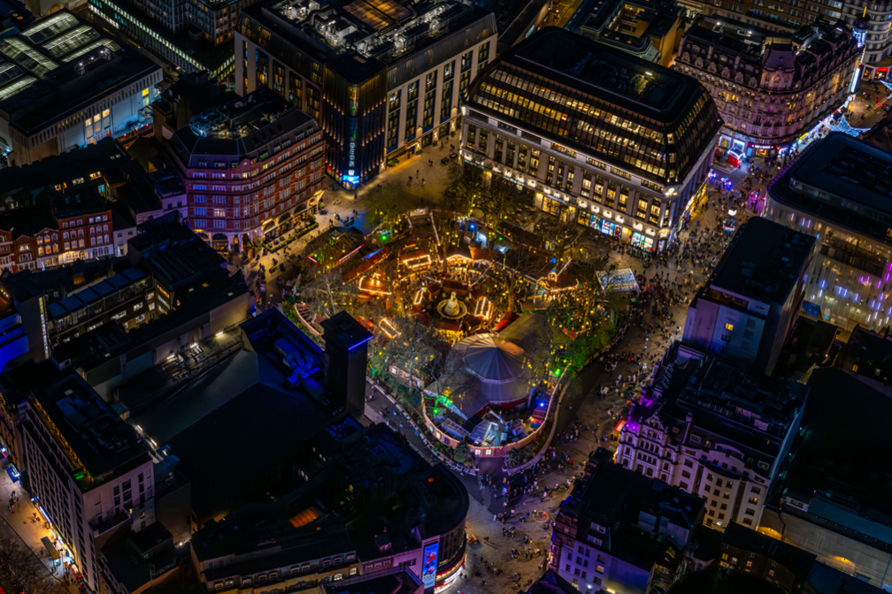 Aerial photograph taken at night showing lights, buildings and a big top in Leicester Square