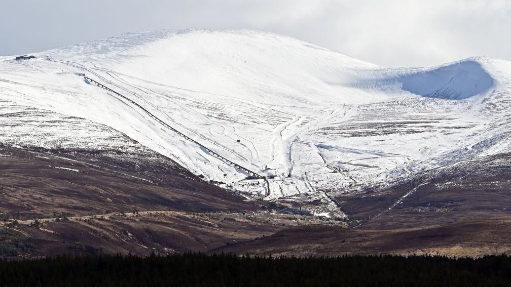 A mountain with snow on the highest parts but none further down