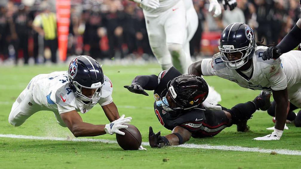 Tyler Lockett Arizona mergulha na bola para marcar um touchdown para o Tennessee Titans contra os cardeais