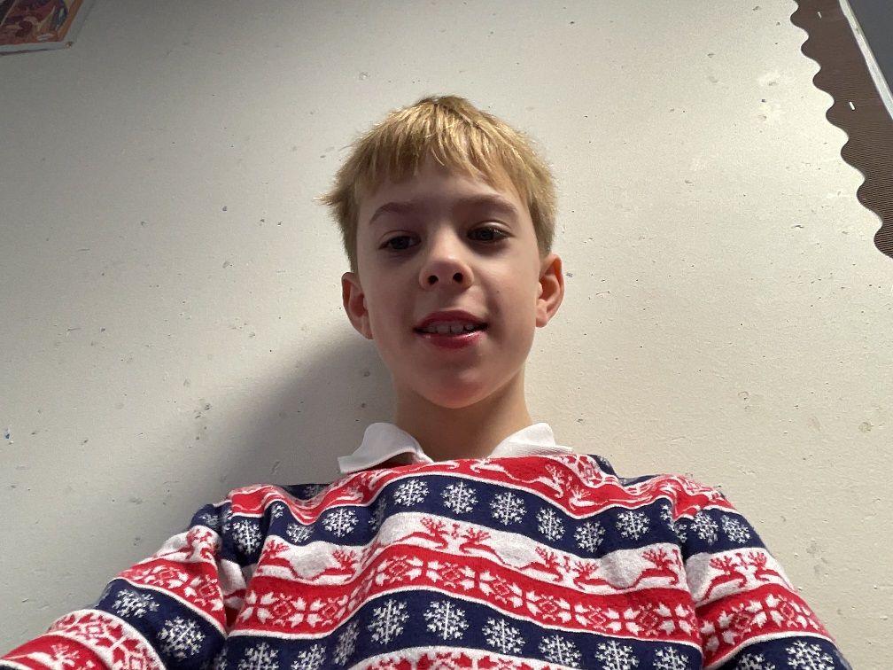 a boy in a christmas jumper with snowflakes and reindeer