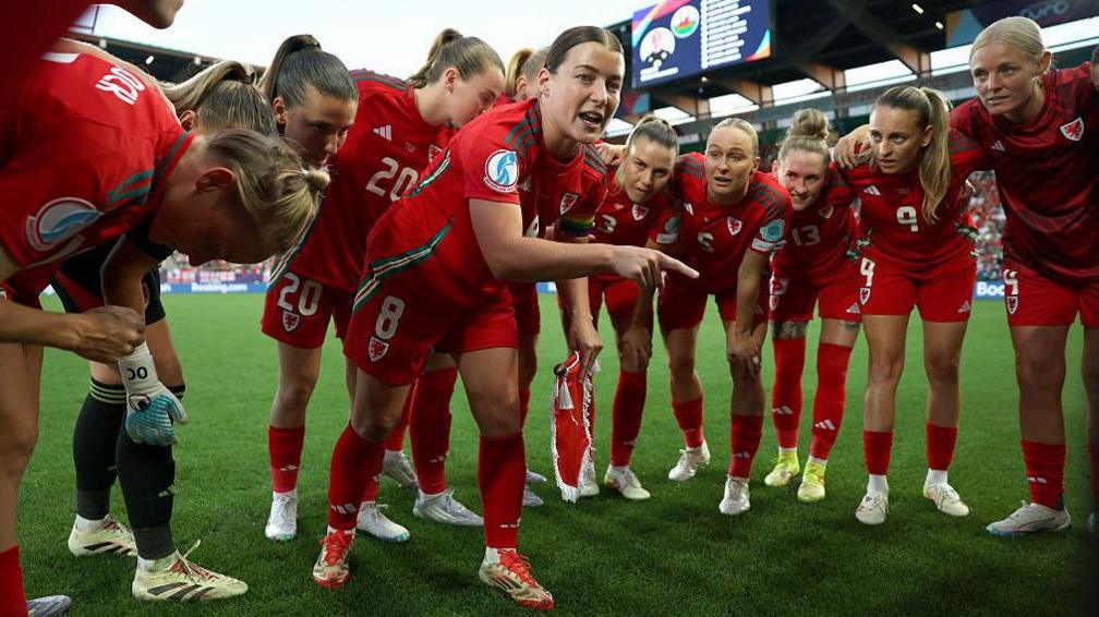 Angharad James yn siarad gyda'i chyd-chwaraewyr cyn y gên yn erbyn Lloegr yn Euro 2025