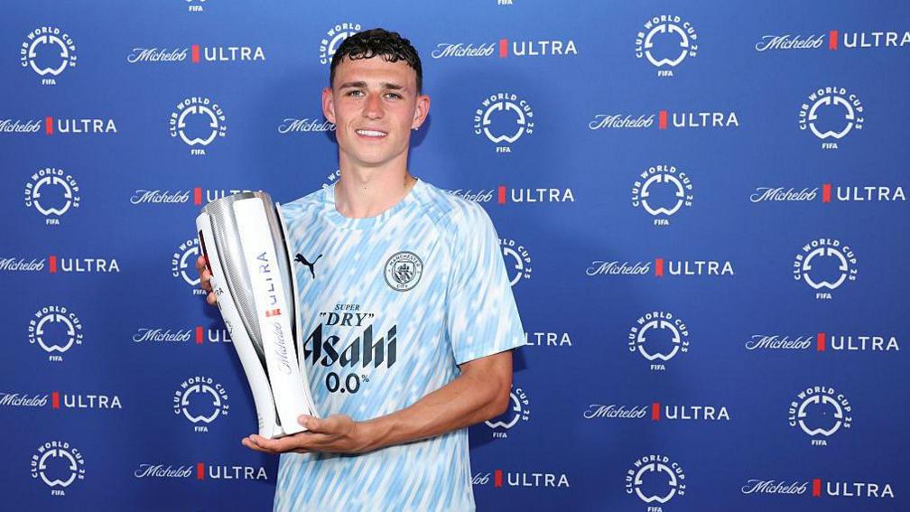 Phil Foden  holding the Superior Player of the Match trophy pursuing  Manchester City's triumph   implicit    Al Wydad