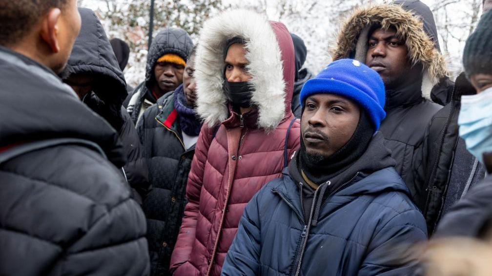 Single migrant men, mostly from West Africa, hold an impromptu meeting to discuss their lack of shelter and working papers on 17 February 2024 in Tompkins Square Park in the East Village neighbourhood of New York City, New York