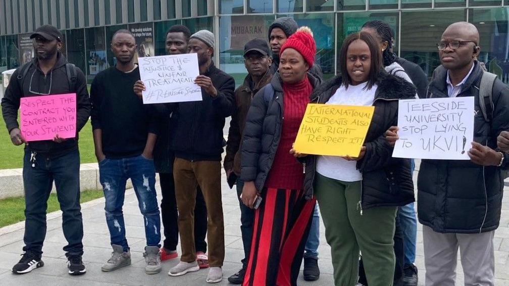 A group of Teesside University students holding placards