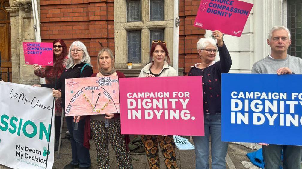 Campaigners with Dignity in Dying signs outside the House of Keys