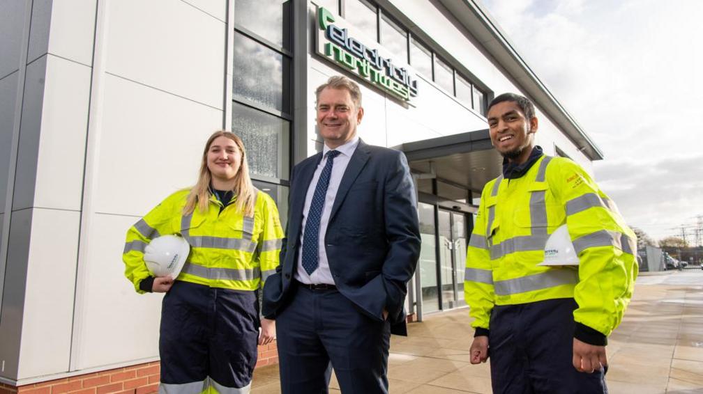 Ian Smyth, chief executive officer at Electricity North West, with two apprentices