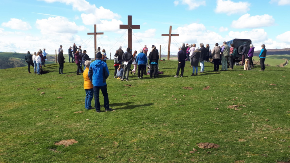 People gather around the crosses