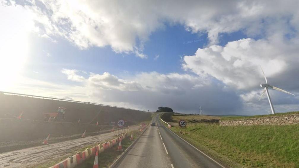 Image showing B3288 on a sunny but cloudy day with orange cones lining the inside of the road and large, round 40mph road signs.