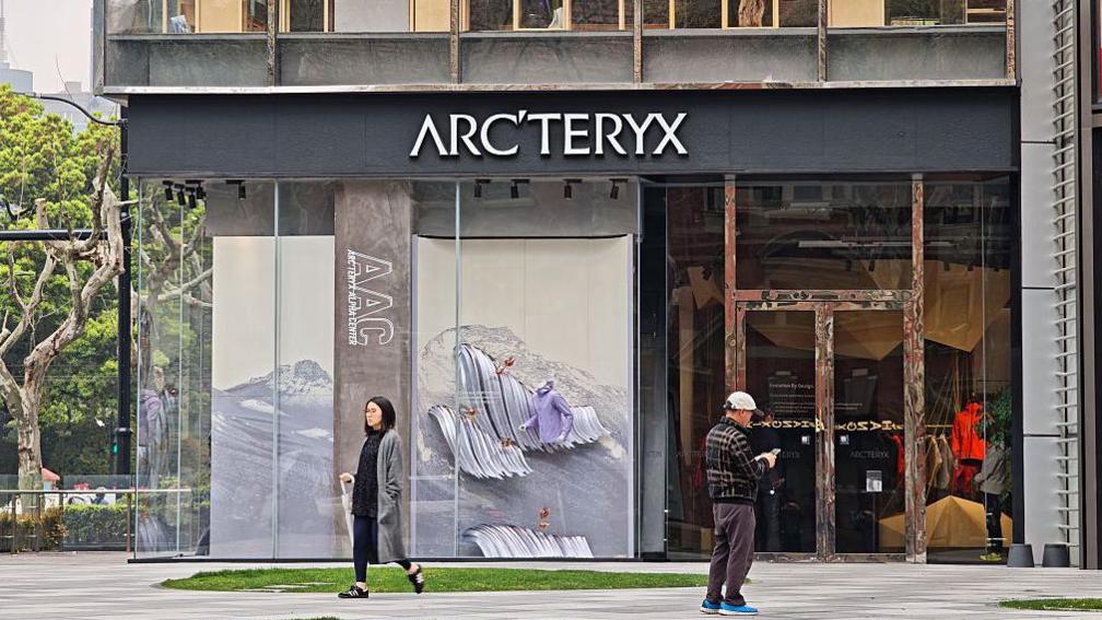 Pedestrians walk past a Arc'teryx flagship store in Shanghai, China on March 27, 2025.