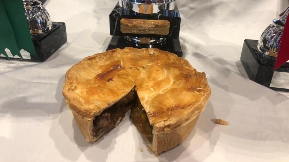 A steak and ale pie cut open showing the filling and even pastry case