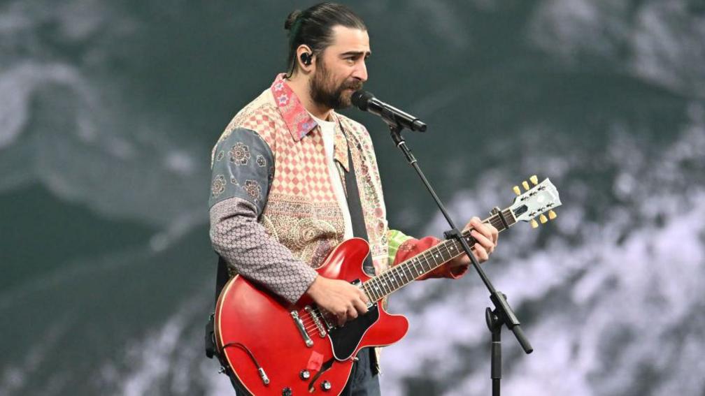 noah kahn on stage playing guitar