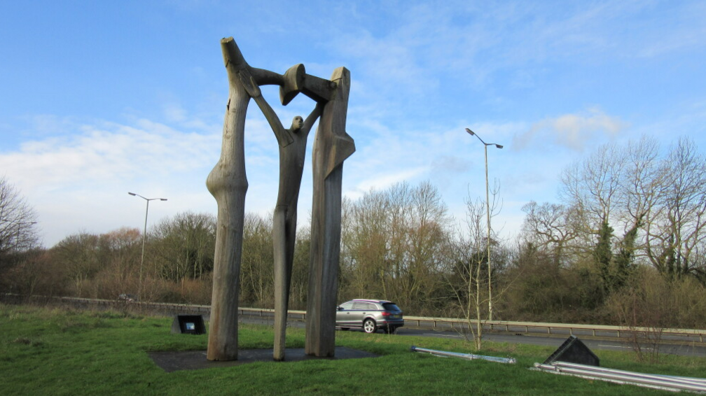 The Peterborough Arch is an abstract sculpture of a wooden man standing under a wooden arch.