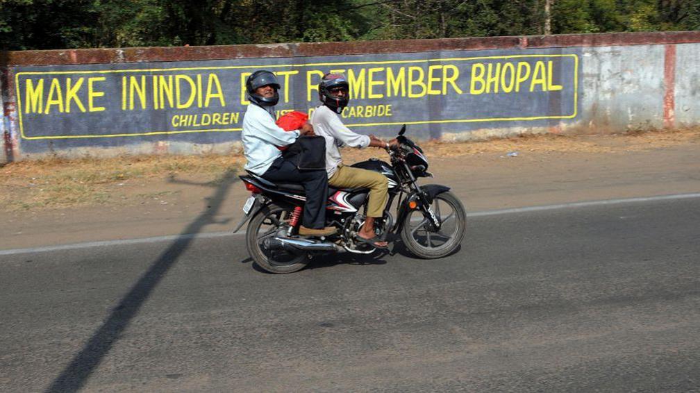 BHOPAL, INDIA - DECEMBER 2: 'Make In India but Remember Bhopal' written on the Union Carbide plant wall put up by gas activists reminding the government about the Bhopal gas disaster in the backdrop of the government's policy of inviting MNCs to set up production units in India, on the eve of 31st anniversary of Bhopal Gas tragedy on December 2, 2015 in Bhopal, India. Over 3,000 people were believed to have died in the Bhopal gas leak tragedy that took place on the night of December 2-3, 1984. The protesters wanted the government to revise the number of deaths and injuries it is seeking compensation from Union Carbide Corporation (UCC) - the US-based owner of Union Carbide India (UCIL) at the time of the accident - and Dow Chemical Company, which acquired UCC in 2001. (Photo by Praveen Bajpai/Hindustan Times via Getty Images)