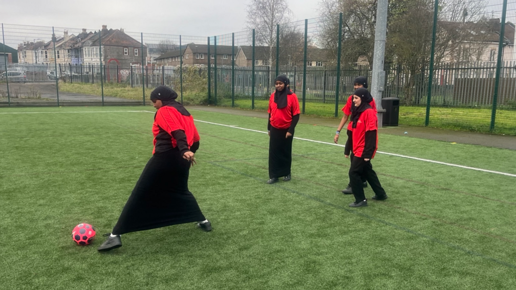 Girls wearing hijabs playing football