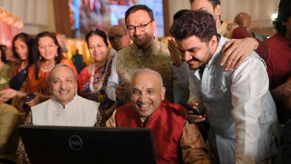 A stock broker and his family watch a terminal during a special trading session for Diwali, the Hindu festival of lights, at the Bombay Stock Exchange (BSE) in Mumbai, India, on November 1, 2024. 