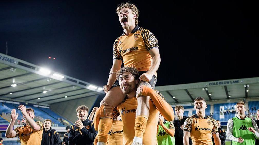 Regan Slater sits on the shoulders of Matt Crooks as Hull's players celebrate in front of their fans