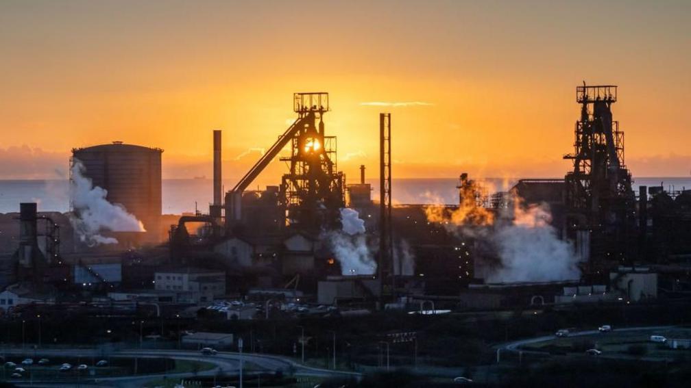 The Tata Steel plant in Port Talbot with a low sun and orange sky in the background