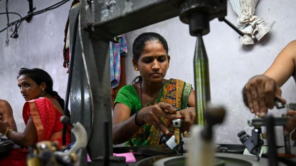 Women employees work on diamond polishing machines at a factory in Surat. 