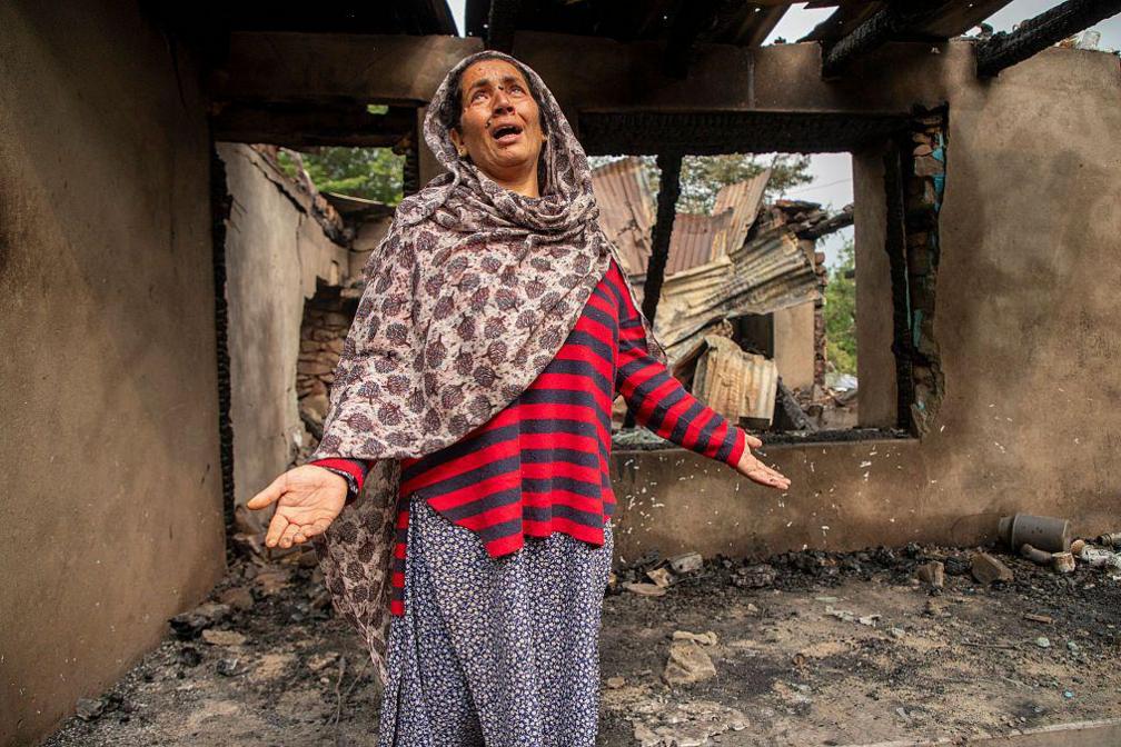 A Kashmiri woman stands inside her shell-damaged home in Salamabad, near the LoC in Uri