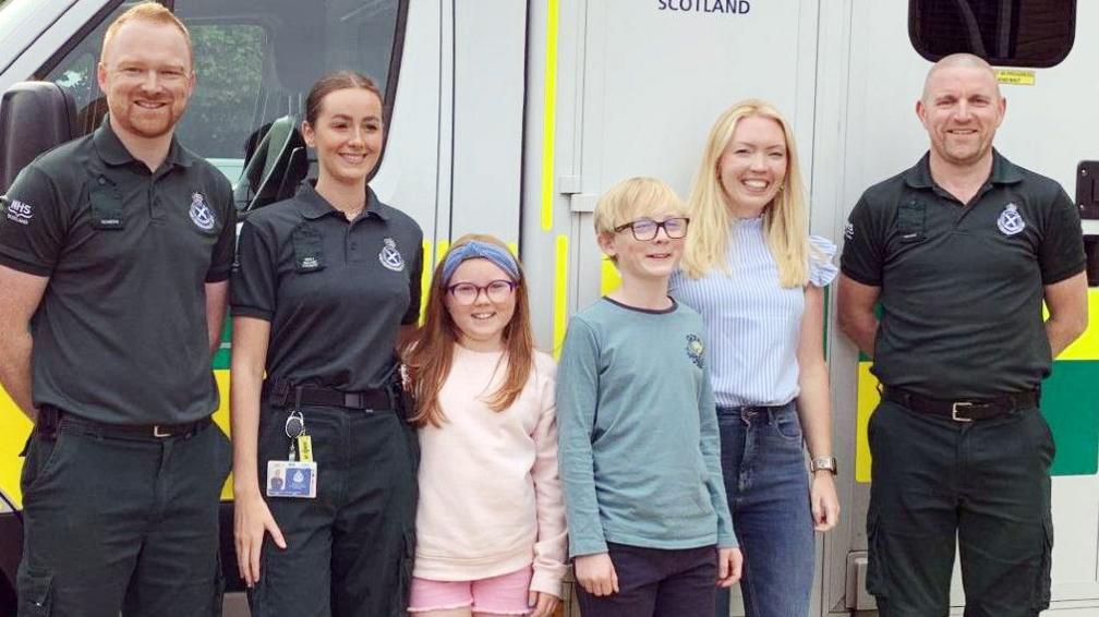 Arianna, Oliver and mum Donna with ambulance workers who came to her aid