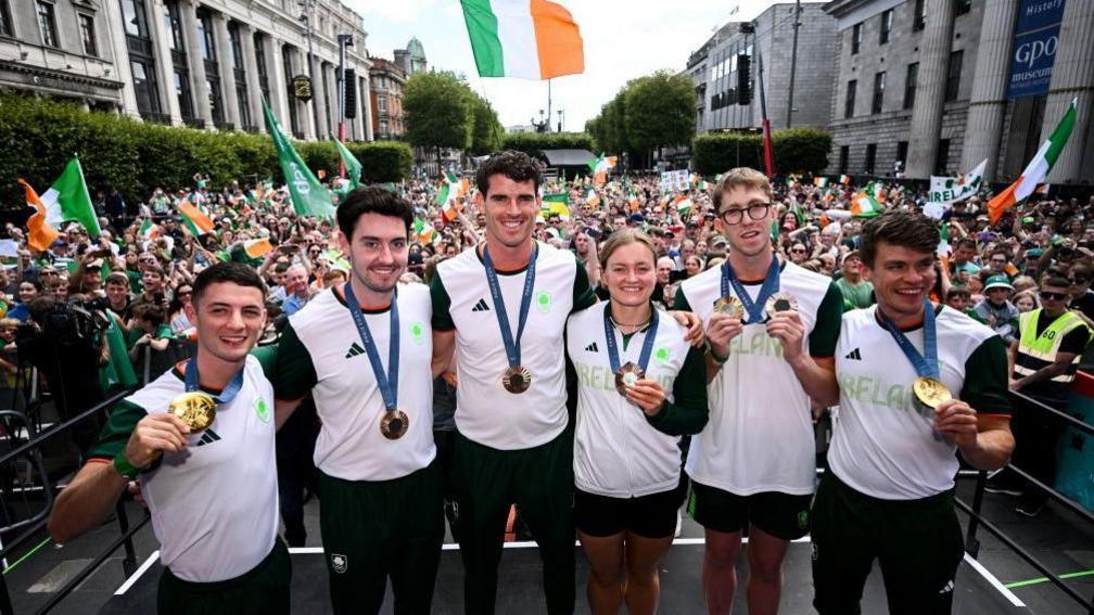 Rhys McClenaghan, Daire Lynch, Philip Doyle Mona McSharry, Daniel Wiffen and Fintan McCarthy hold up their medals 