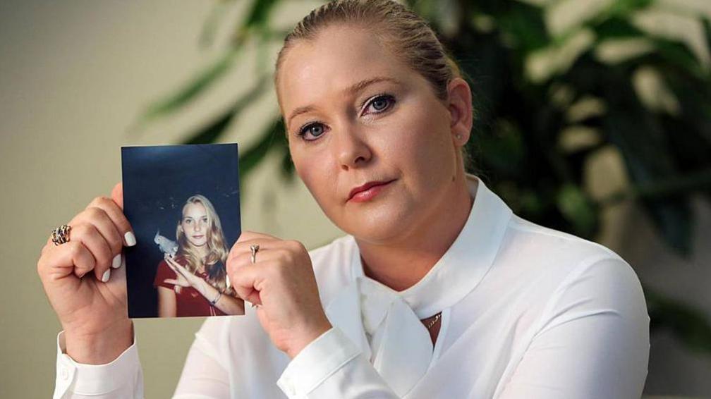 Virginia Giuffre with a photo of herself as a teenager