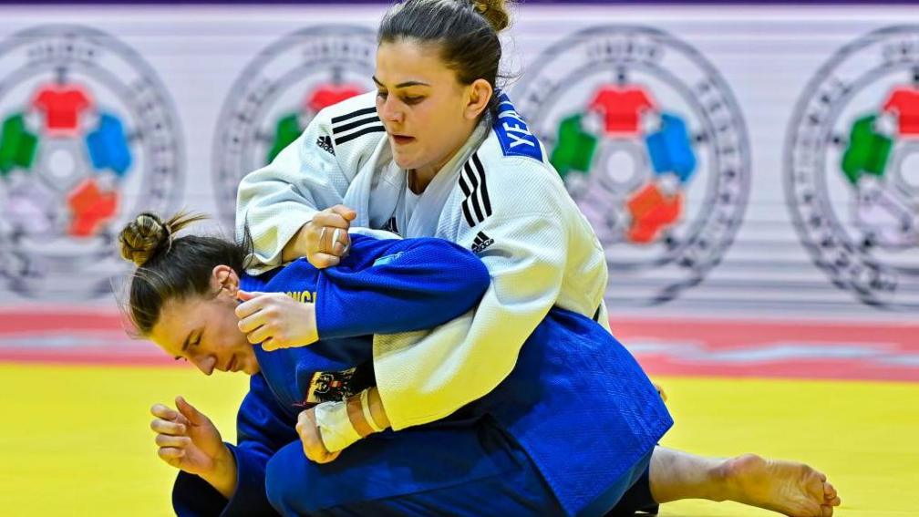 Michaela Polleres (blue) of Austria and Jemima Yeats-Brown, wearing white, of Great Britain, compete during the women's -70kg of the World Judo Championships 2023 in Doha, Qatar