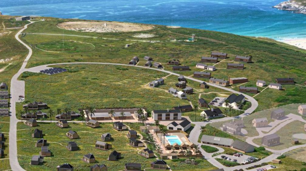 An aerial view of a number of holiday lodges with the sea in the distance