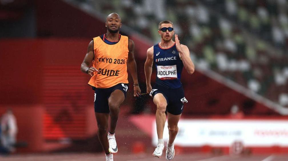 Timothee Adolphe running with his guide