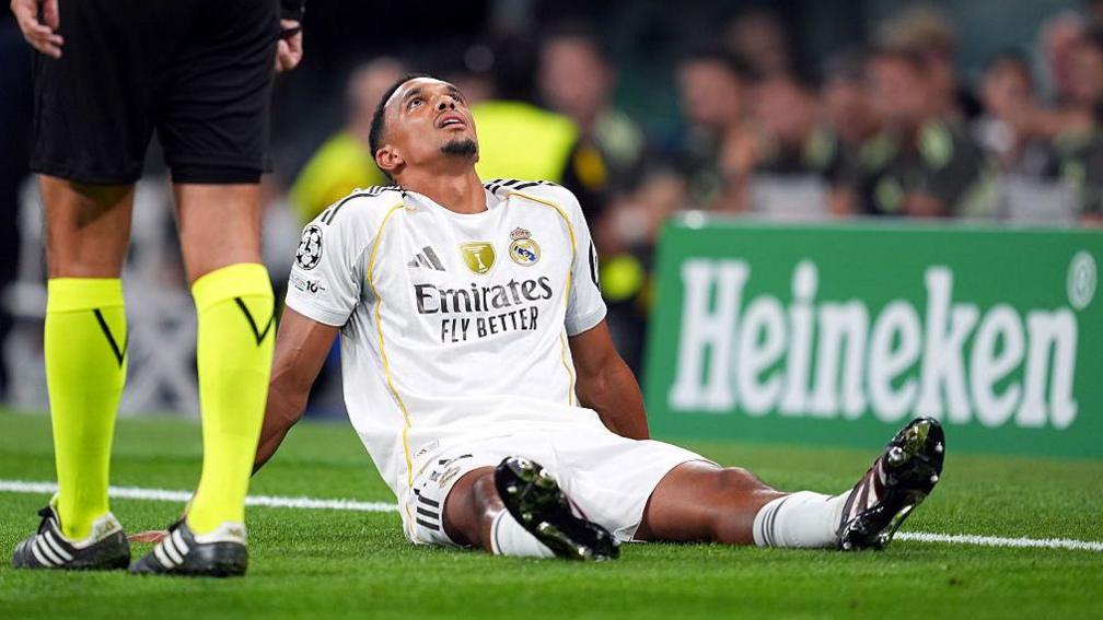 Trent Alexander-Arnold sits on the floor and looks up to the sky