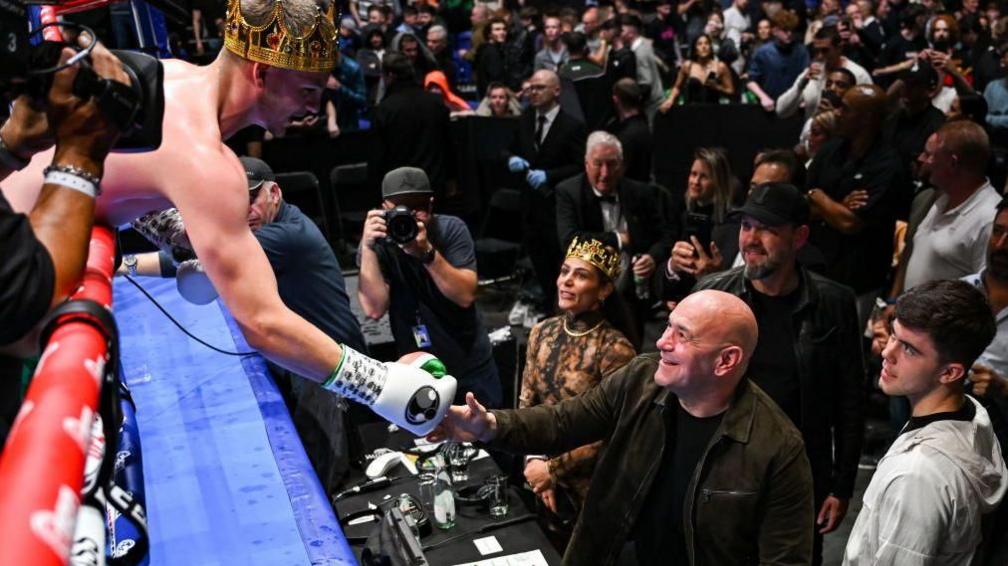 Callum Walsh leans over the ropes to shake the hand of Dana White