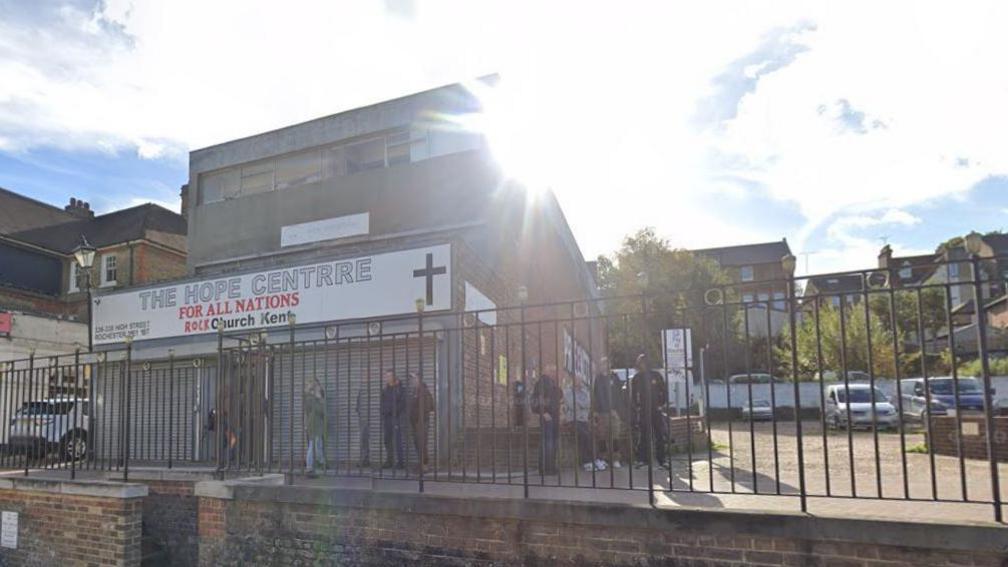 A Google Maps image of Rock Church Kent in Rochester Highstreet, a brick building next to a run down carpark