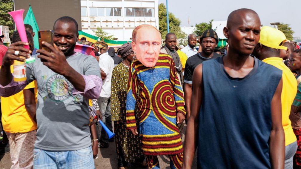 A supporter of Malia's junta wears a face mask of the President of Russia, Vladimir Putin, during a rally in Bamako on May 13, 2022