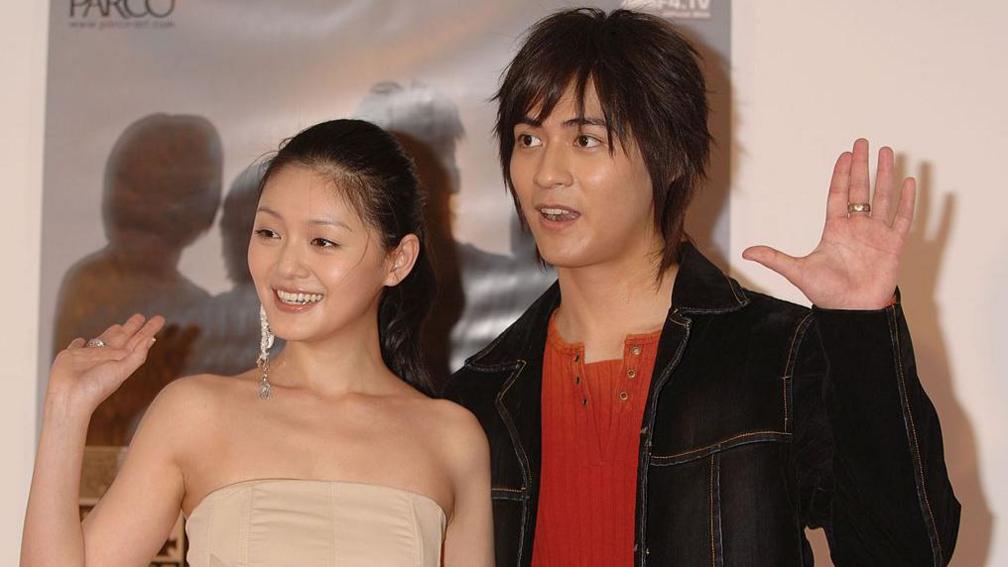 Hsu and Vic Chou standing side by side and raising their hands at an event in Tokyo