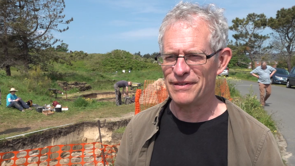 States archaeologist Phil de Jersey stands in front of the excavation site in Guernsey