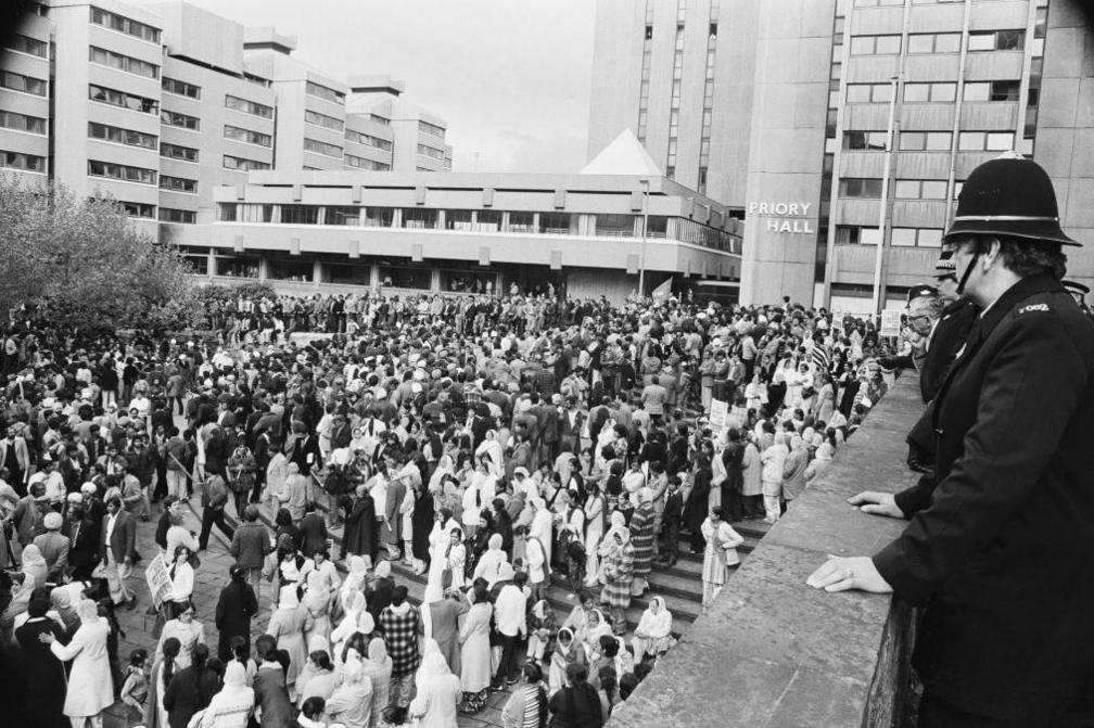 Police officers look over a balcony as crowds gather in Centenary Square, Coventry for a demonstration against racism