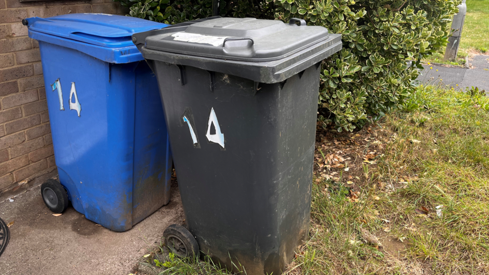 A blue and a black bin next to each other