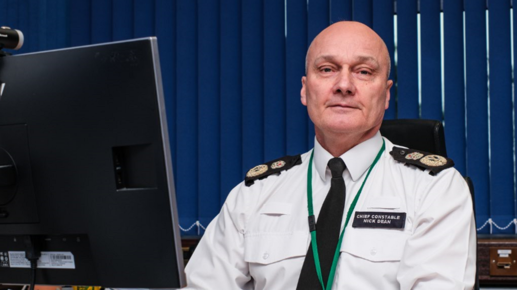 Police chief in uniform at a desk