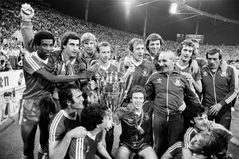 Nottingham Forest players line up for a team celebration photograph. Viv Anderson, far left, helps hold the European Cup trophy.