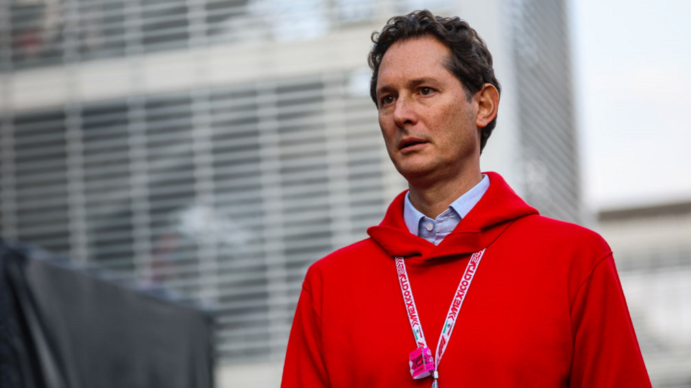 Stellantis chair John Elkann, wearing red hoodie over a light blue shirt with racing lanyard around his neck