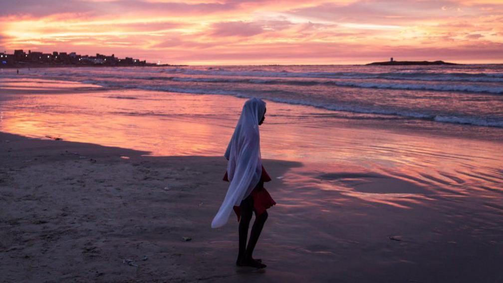 An image of a young girl walking along a beach in Dakar, Senegal during the celebrations of the birth of the Prophet Muhammad - Sunday 15 September 2024. 