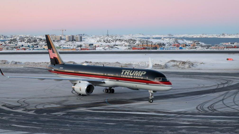 An airplane with the name Trump taxis at an airport in Greenland