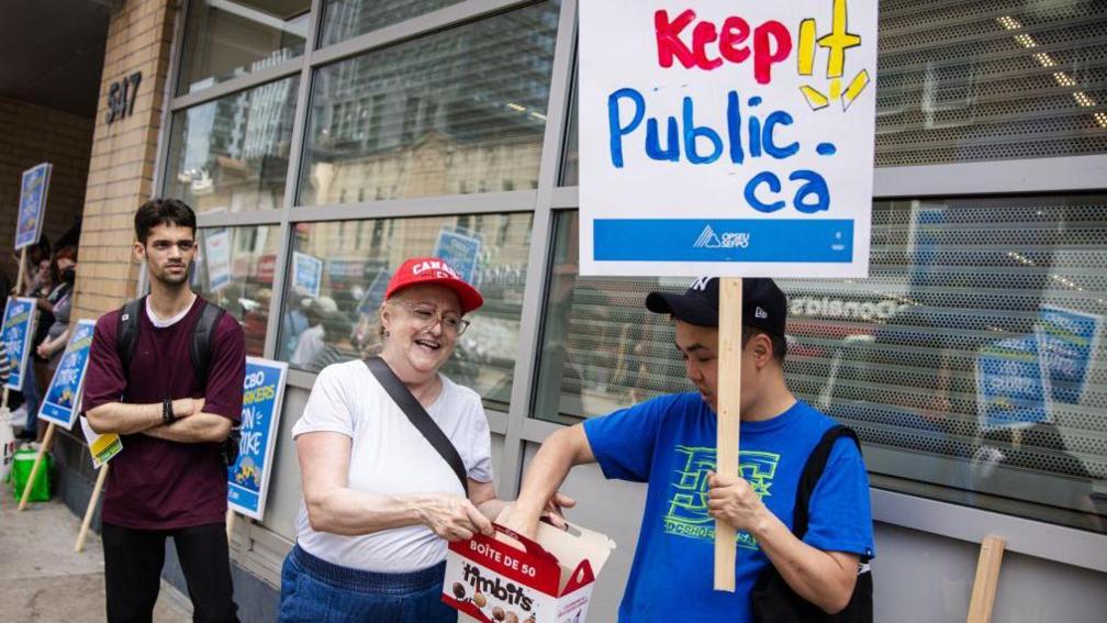  Cindy Wray who has worked at the LCBO for 13 years hands out timbits to people on the picket line.