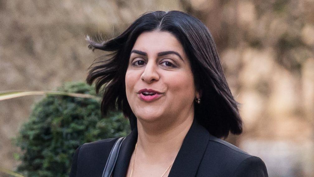 Justice Secretary Shabana Mahmood, wearing a black blazer and gold jewellery, walking towards Downing Street