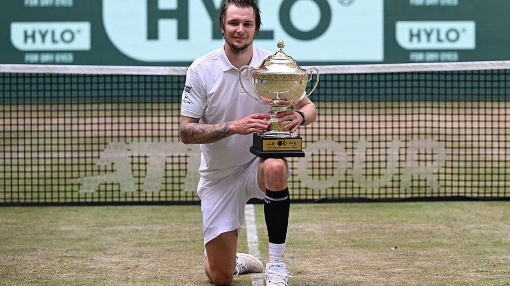 Alexander Bublik holds his Halle Open trophy