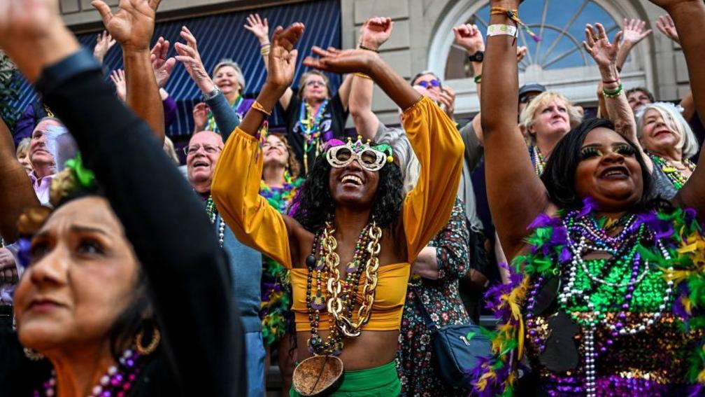 Revellers catch beads from a float in the 2023 Zulu Social Aid and Pleasure Club parade during a Mardi Gras celebration in New Orleans, Louisiana, February 21, 2023. - Shrove Tuesday 2023 marks the end of the Mardi Gras festival in Louisiana. 