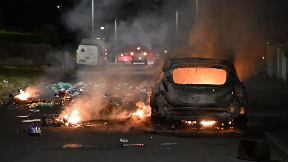 Car on fire during Ely riot