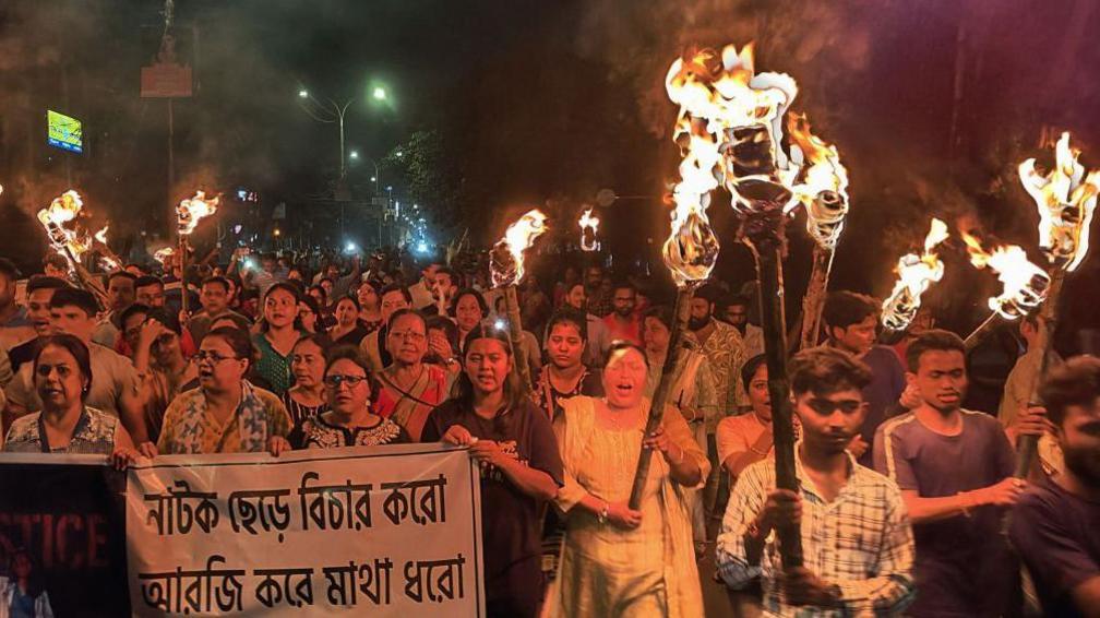 Medical professionals, activists and citizens of Siliguri chant as they take part in a protest march named 'The Night is also ours' to condemn the rape and murder of a young medic, in Siliguri on 14 August, 2024