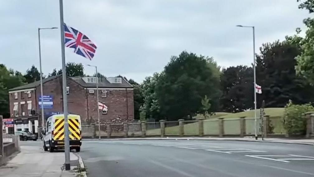 A union flag and two St George's flag on lamp-posts in Liverpool