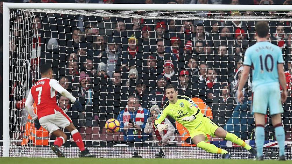 Alexis Sanchez scores a 98th-minute penalty for Arsenal against Burnley in 2017. Tate is behind Clarets goalkeeper Tom Heaton